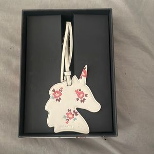 Coach tag with horse shape. And pink flowers on cream background